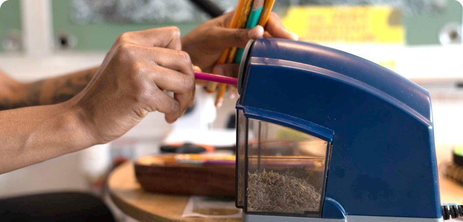 closeup photo of someone sharpening colorful pencils